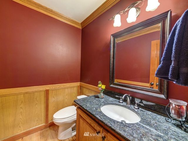 a bathroom with a granite countertop sink toilet and a mirror