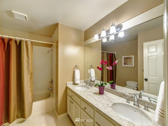 a bathroom with a double vanity sink mirror double and shower