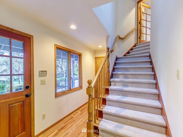 a view of staircase with lots of frames on wall and a window