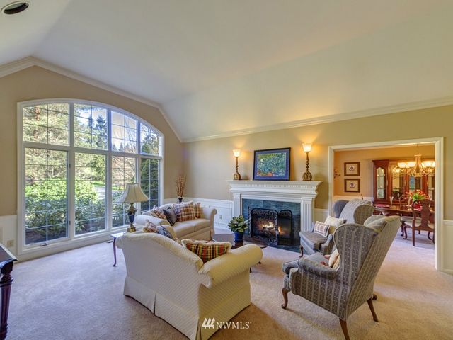 a living room with furniture a fireplace and a large window