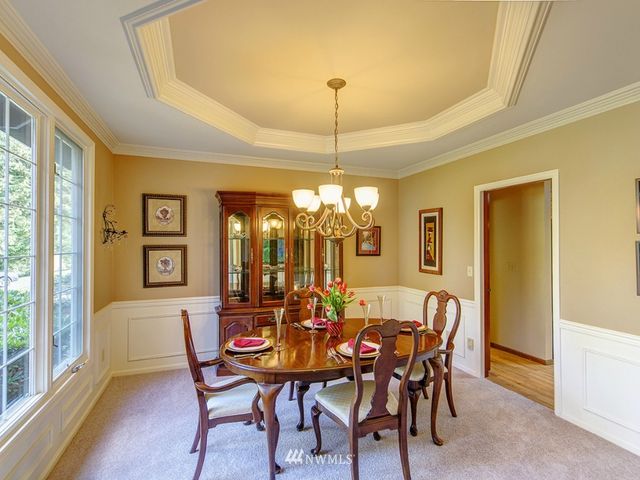a view of a dining room with furniture and chandelier
