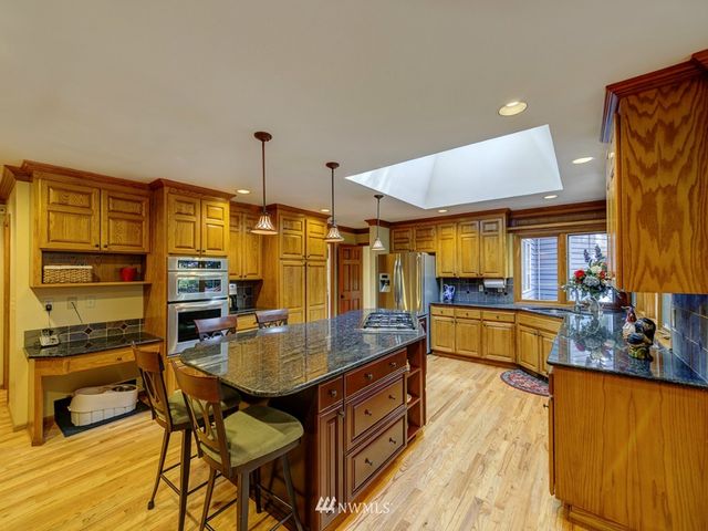a kitchen with stainless steel appliances granite countertop a stove a sink and a refrigerator