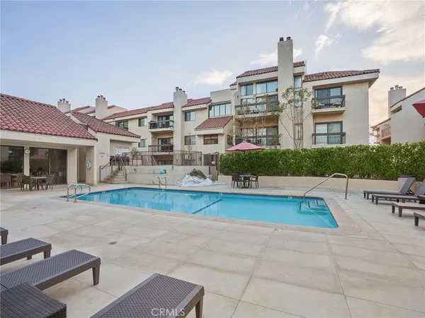a swimming pool with outdoor seating and yard in the back