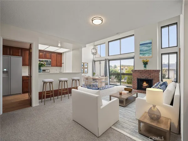a living room with furniture a fireplace and a large window