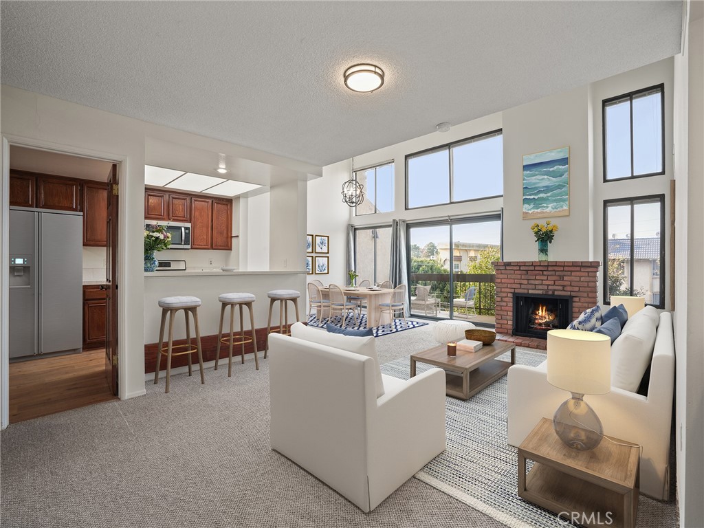 8180 Manitoba Street, Unit 302 Playa del Rey, CA 90293 - Photo 5 of 31 a living room with furniture a fireplace and a large window