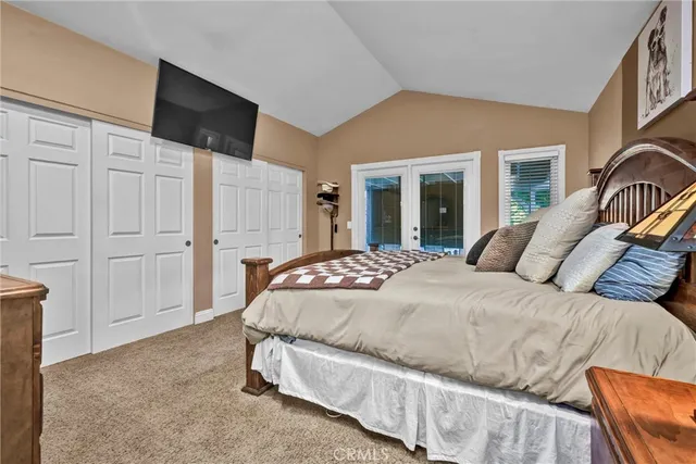 a spacious bedroom with a bed and a flat screen tv
