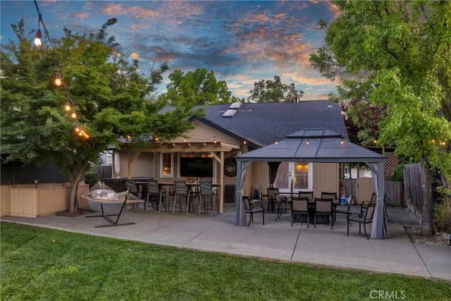 a patio with couches table and chairs under an umbrella