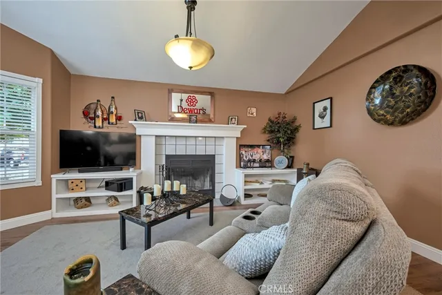 a living room with furniture a flat screen tv and a fireplace