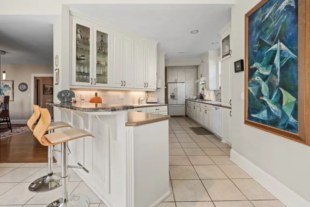 a kitchen with stainless steel appliances granite countertop a sink and a refrigerator