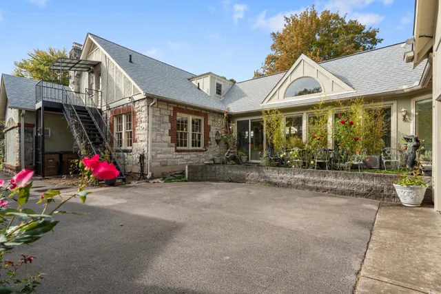 a view of a house with a yard and potted plants