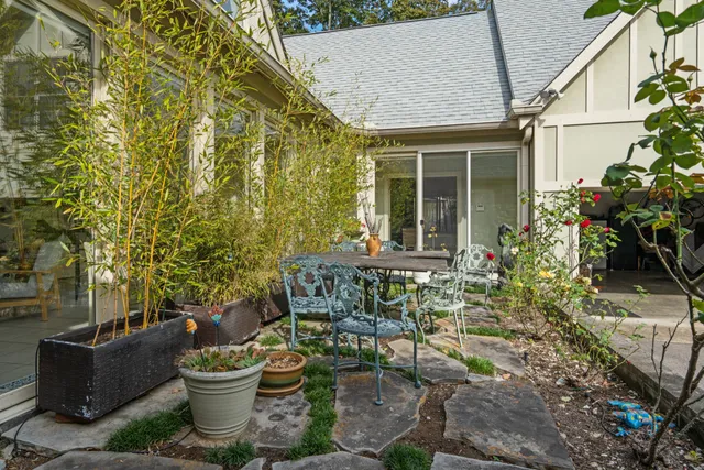 a view of a house with backyard and sitting area