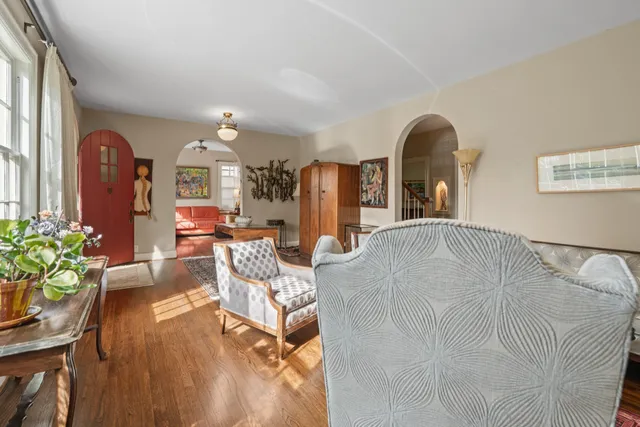 a living room with furniture a chandelier and wooden floor