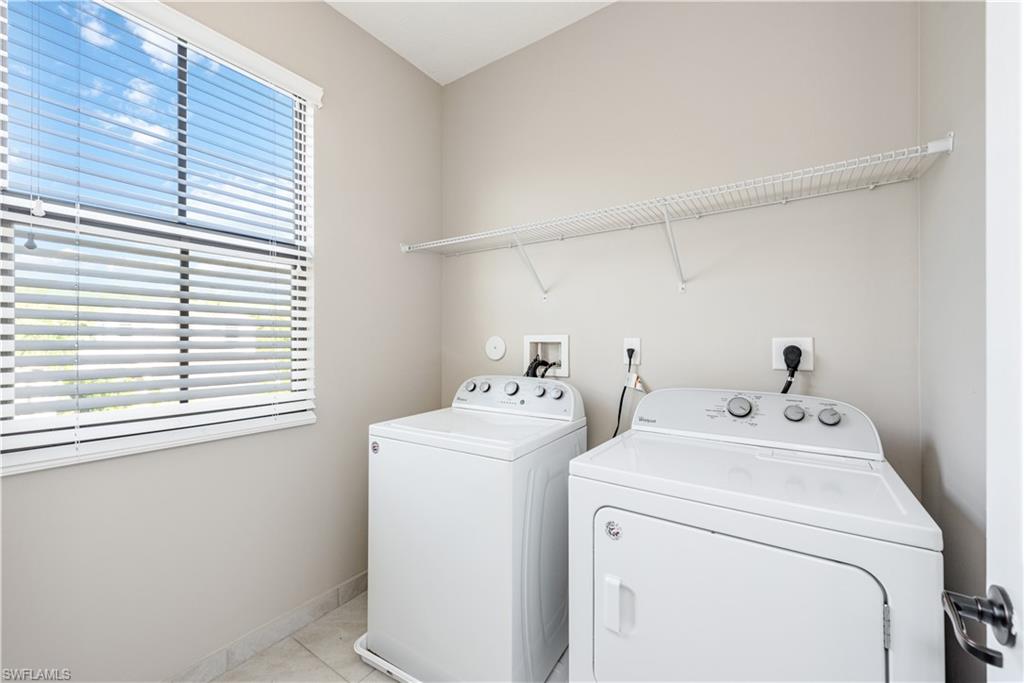 8732 Madrid Circle Naples, FL 34104 - Photo 13 of 15 Laundry room featuring light tile patterned floors and washing machine and clothes dryer