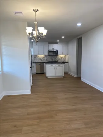 a kitchen with a sink stainless steel appliances and chandelier
