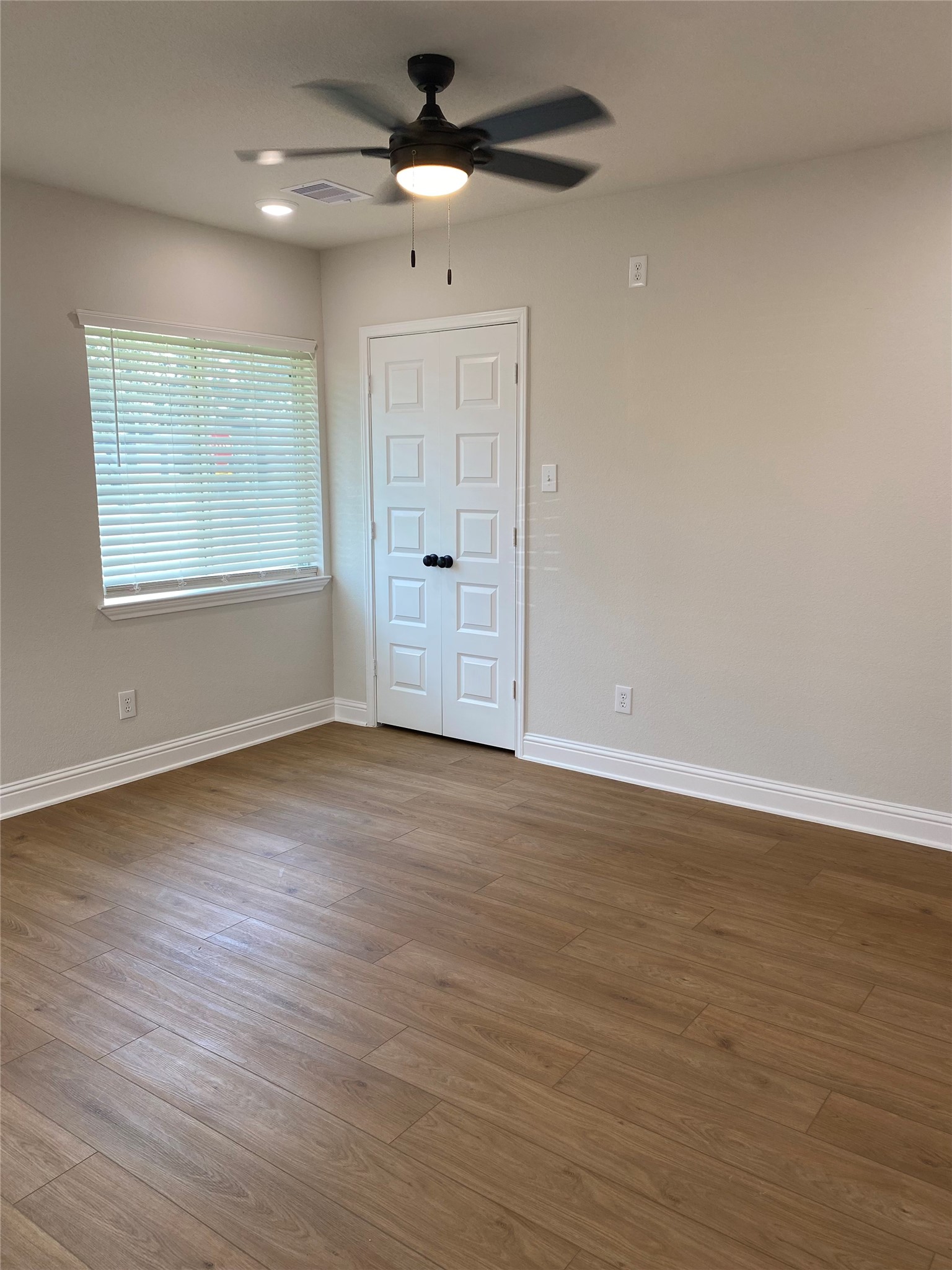 4901 Winnetka Street Houston, TX 77021 - Photo 28 of 45 an empty room with wooden floor chandelier fan and windows