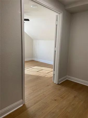 a view of empty room with wooden floor