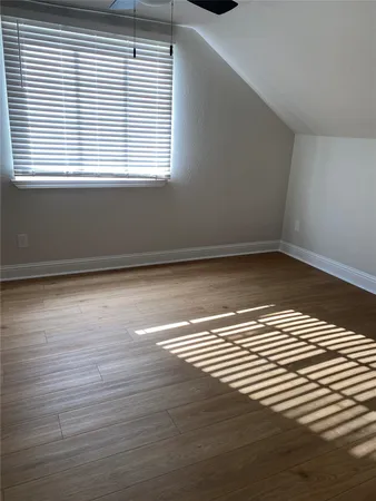 a view of a room with wooden floor and a window