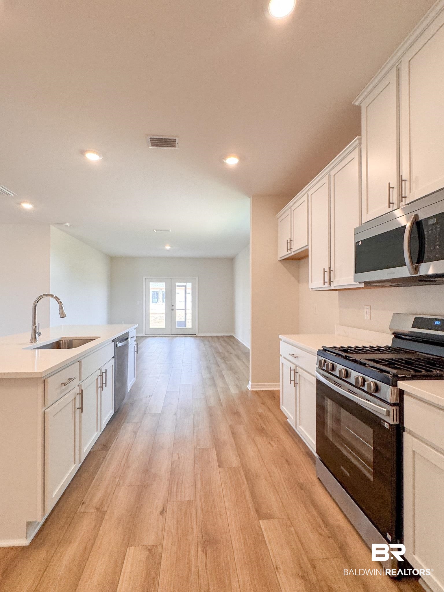 18151 Kent Circle Foley, AL 36535 - Photo 7 of 25 Modern kitchen featuring light wood-finish flooring, white cabinetry, stainless steel appliances, and recessed lighting