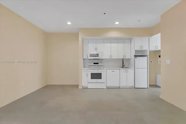 a view of a kitchen with white cabinets