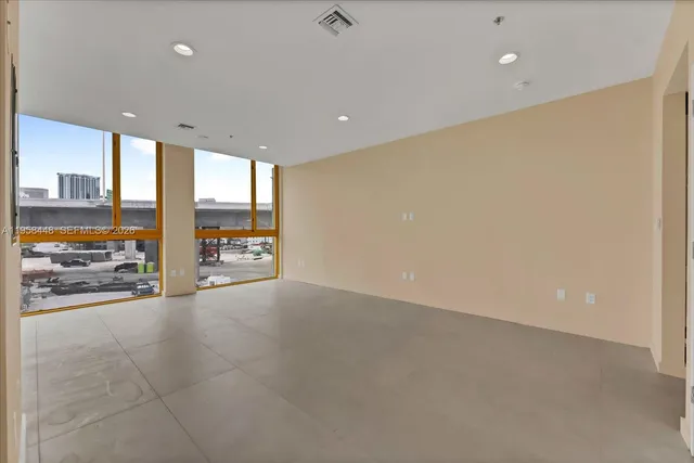 an empty room with cabinet and windows