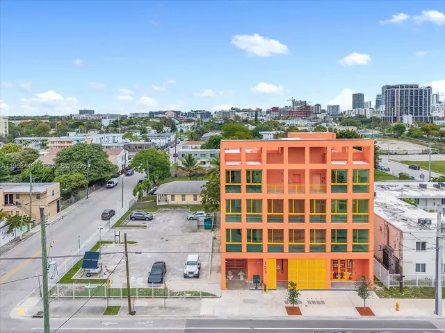 a front view of a building with streets and trees