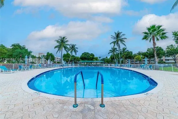 a view of a swimming pool and trees in the background