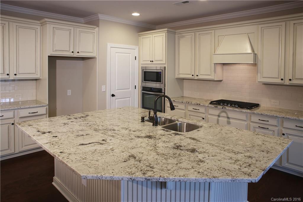 1033 Emory Lane, Unit 70 Fort Mill, SC 29708 - Photo 3 of 21 a kitchen with kitchen island granite countertop a sink stove and refrigerator