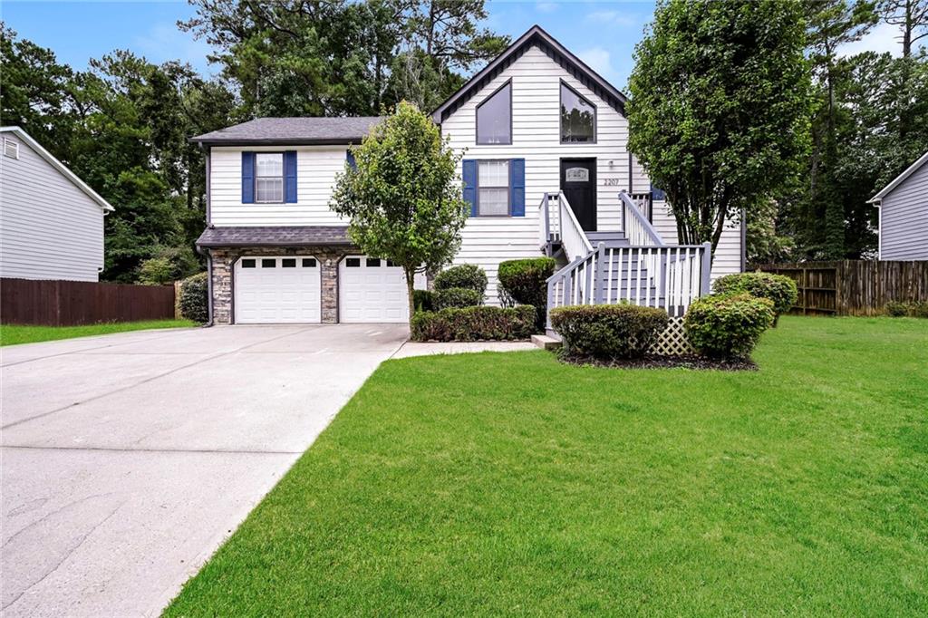 a front view of a house with a yard and trees