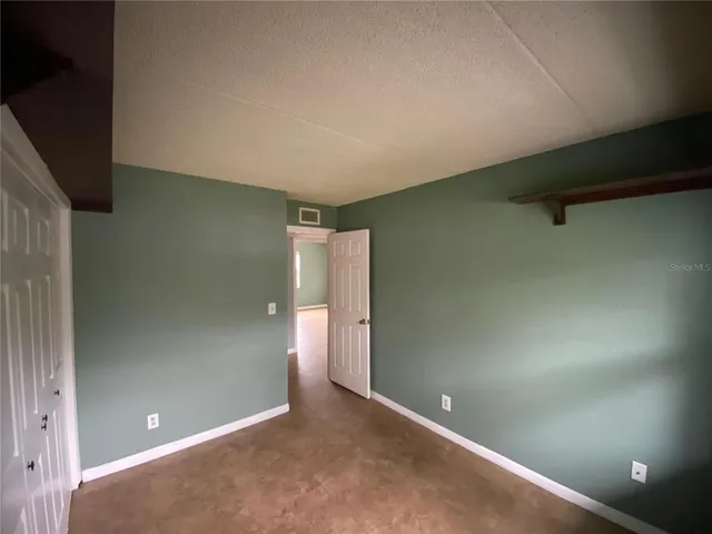 an empty room with closet and wooden floor