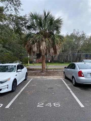 a view of swimming pool that has lawn chairs with plants and trees