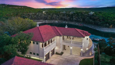 a aerial view of a house with a yard and lake view