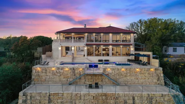 a front view of a house with swimming pool and sitting area