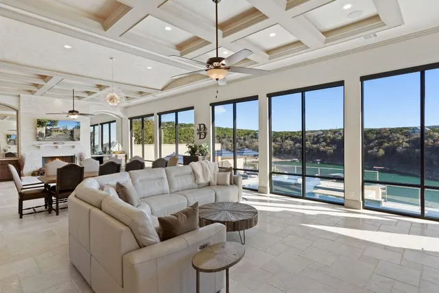 a living room with furniture ceiling fan and a large window