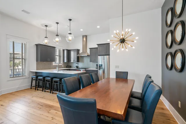 a kitchen with stainless steel appliances kitchen island granite countertop a dining table chairs and granite counter tops