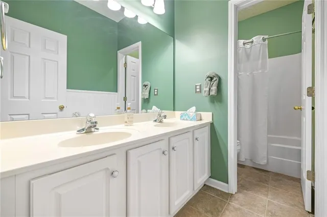 a bathroom with a double vanity sink mirror and bathtub
