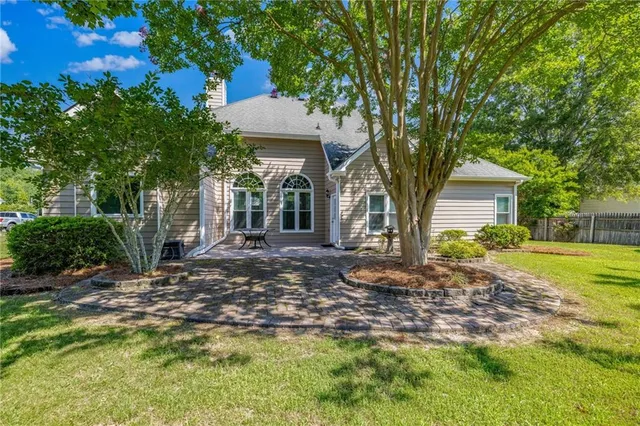 a view of a house with backyard and trees