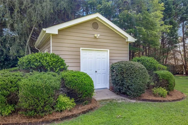 a view of backyard with plants and large trees