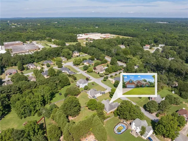 an aerial view of residential houses with outdoor space and trees