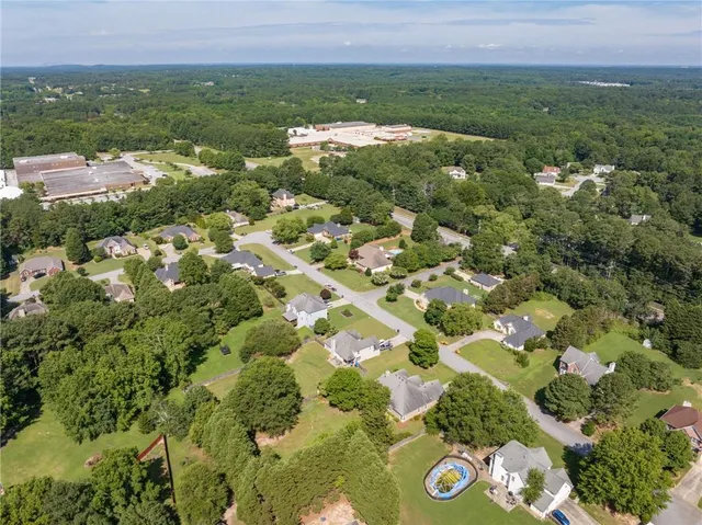 an aerial view of residential houses with outdoor space and trees