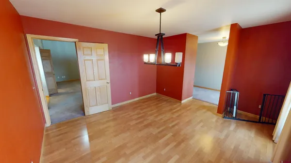 a view of a room with a refrigerator wooden floor and chair