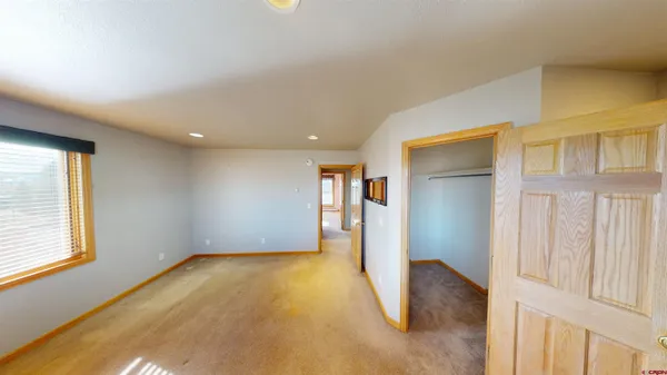 a view of hallway with wooden floor and cabinet