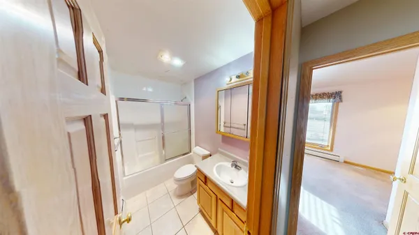 a bathroom with a tub mirror and toilet
