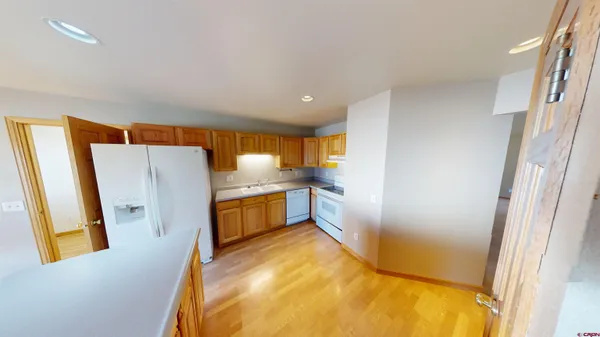 a view of a kitchen with furniture and a refrigerator