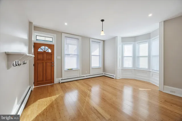 a view of empty room with wooden floor and entryway