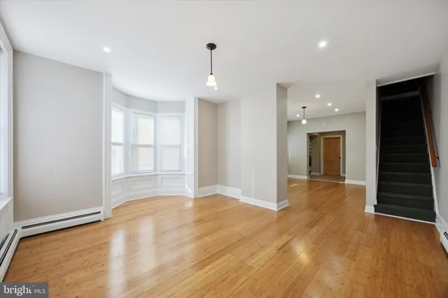 a view of an empty room with wooden floor