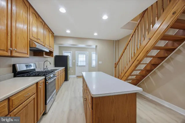 a view of kitchen with sink microwave refrigerator and wooden floor