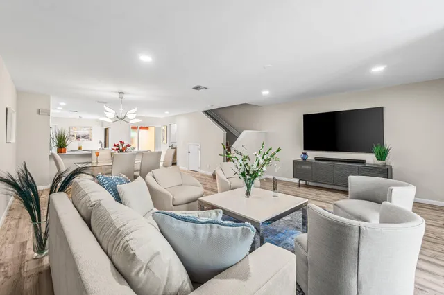 an aerial view of a swimming pool with a yard and outdoor seating