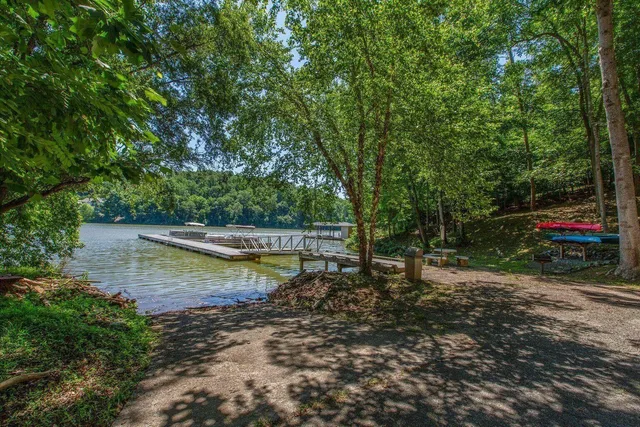 a view of a lake with trees and houses in the back