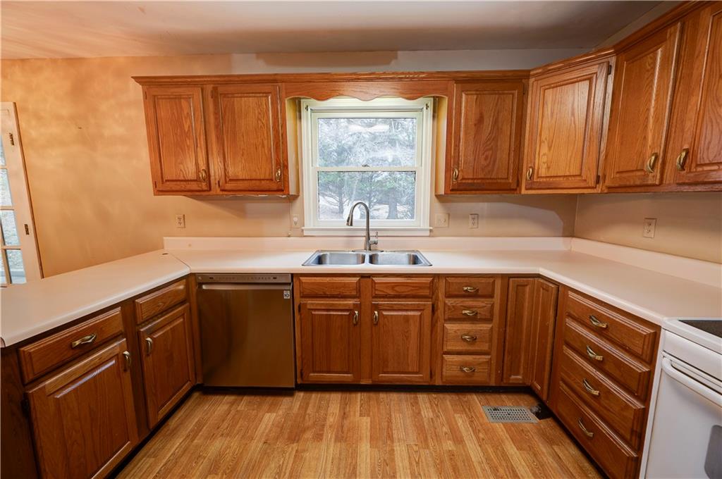 197 Saddlebrook Drive Southeast Calhoun, GA 30701 - Photo 18 of 71 a kitchen with stainless steel appliances granite countertop wooden cabinets a sink and dishwasher with wooden floor