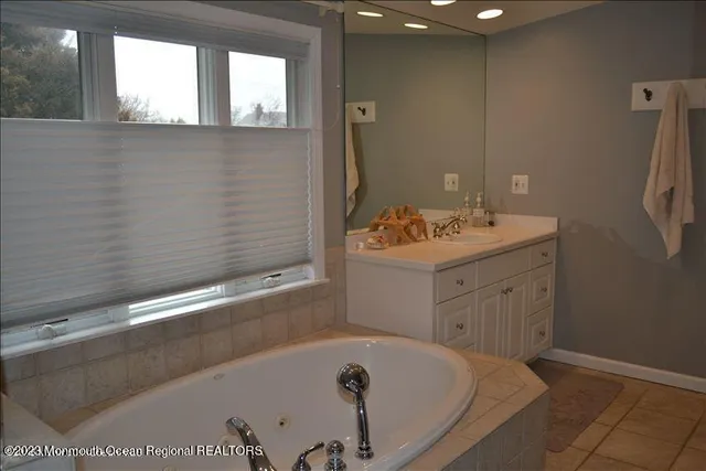 a bathroom with a tub sink and mirror